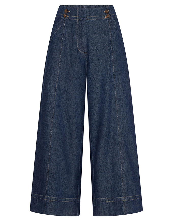 A pair of dark blue wide-leg denim pants with decorative brown buttons on the front waistband, displayed against a solid white background.