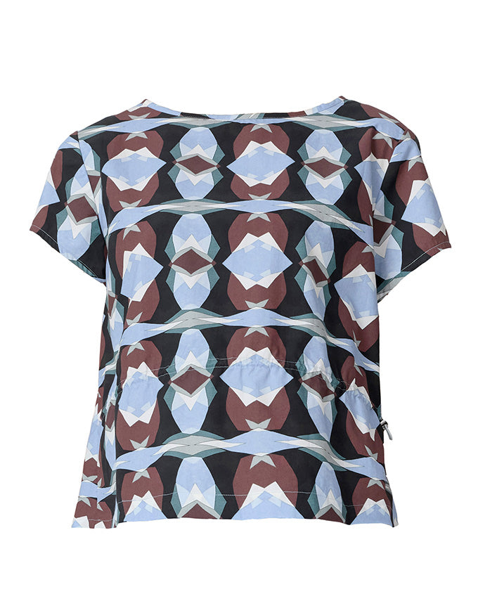 A short-sleeve top with a geometric, kaleidoscopic pattern featuring light blue, brown, white, and black shapes, displayed on a clean white background.