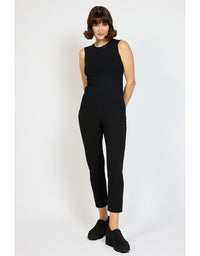 Woman wearing a black sleeveless top and black pants on a white background