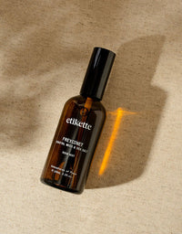 Brown bottle labeled 'etikette' on a textured beige background