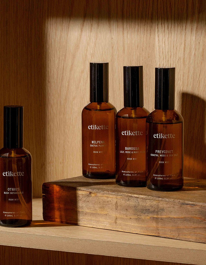 Four etikette skincare bottles on a wooden surface with a warm wooden background