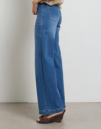 Person wearing blue wide-leg jeans on a plain background
