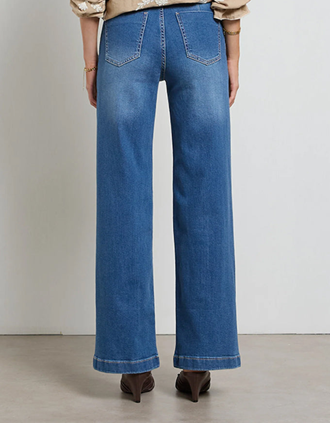Person wearing blue jeans on a plain background