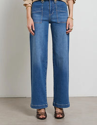 Person wearing blue jeans on a plain background