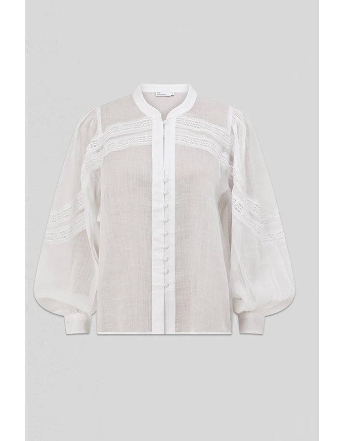 White blouse with sheer sleeves on a light gray background