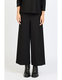 Person wearing a black outfit with wide-leg pants on a white background