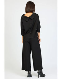 Person wearing a black outfit with wide-leg pants on a white background
