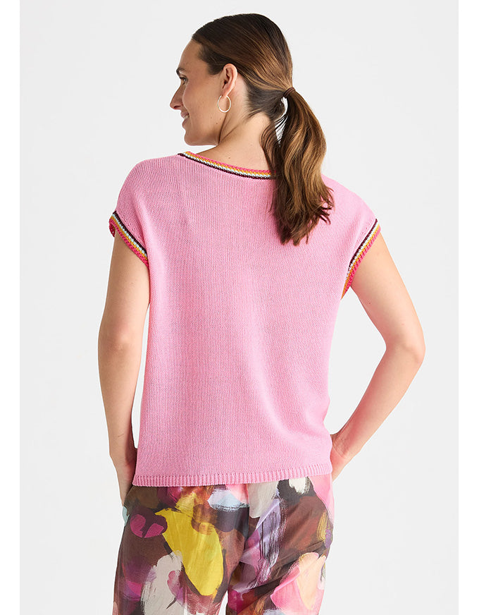 A woman shown from the back wearing a light pink ribbed knit top with colorful striped trim along the neckline and sleeve cuffs, paired with floral print pants, against a light gray studio background. Crochet Trim Tank - Begonia Park