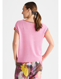 A woman shown from the back wearing a light pink ribbed knit top with colorful striped trim along the neckline and sleeve cuffs, paired with floral print pants, against a light gray studio background. Crochet Trim Tank - Begonia Park