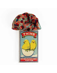 Scarf with a colorful pattern and a vintage-style matchbox design on a white background