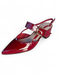 Red patent leather shoe with a gold buckle on a white background