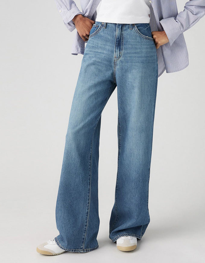 Person wearing light blue jeans on a plain background. Cinch Baggy Jeans - Chasing Dreams