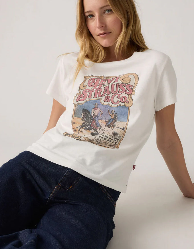 Woman wearing a white t-shirt with Levi Strauss & Co graphic design on a plain background. Graphic Boxy TShirt Western Archival