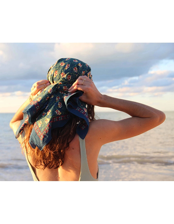 Person with a floral headscarf at the beach
