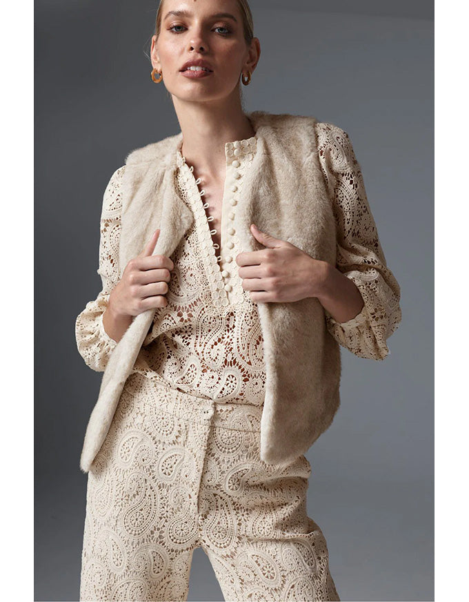 Woman wearing a beige lace outfit against a gray background