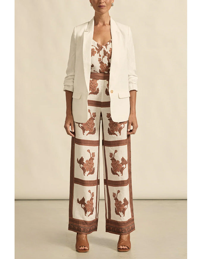 Woman wearing a patterned outfit with a beige background