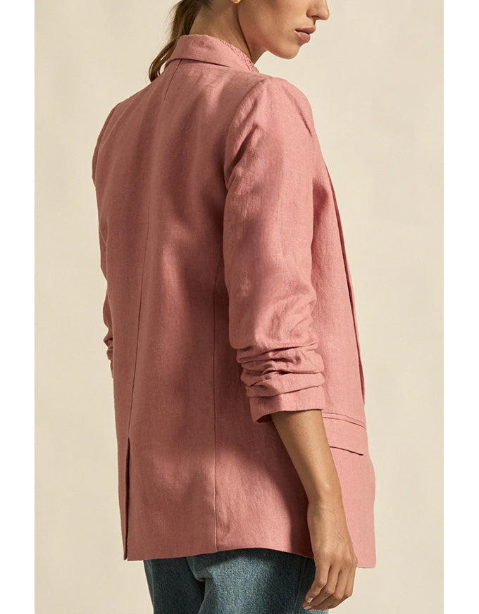 Person wearing a pink jacket on a beige background