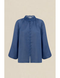 Blue blouse with ruffled collar on a beige background