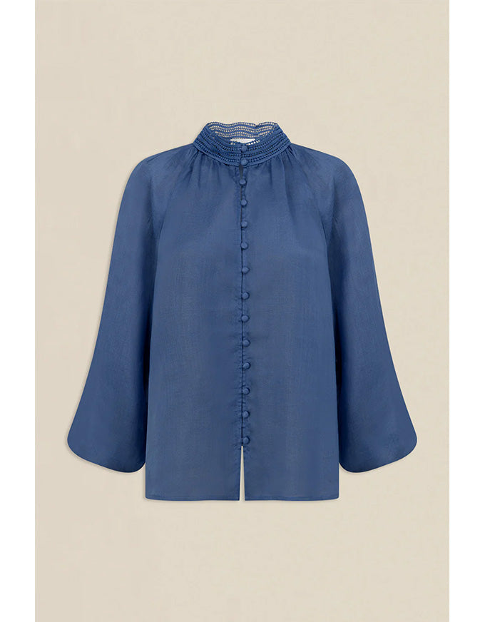 Blue blouse with ruffled collar on a beige background