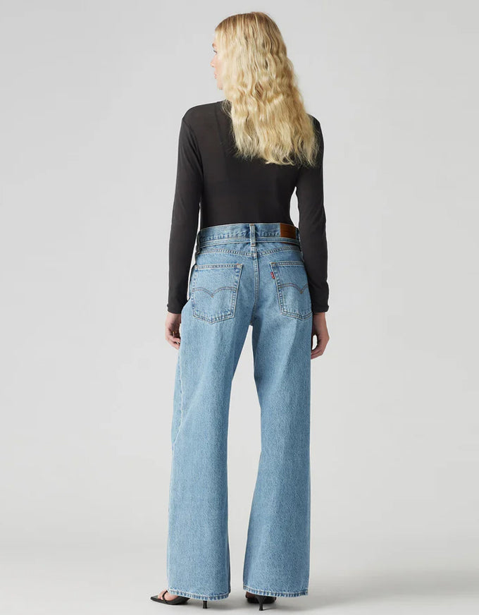 Person wearing light blue jeans and a black long-sleeve top on a plain background. XL Straight Jeans - Thanks Friend
