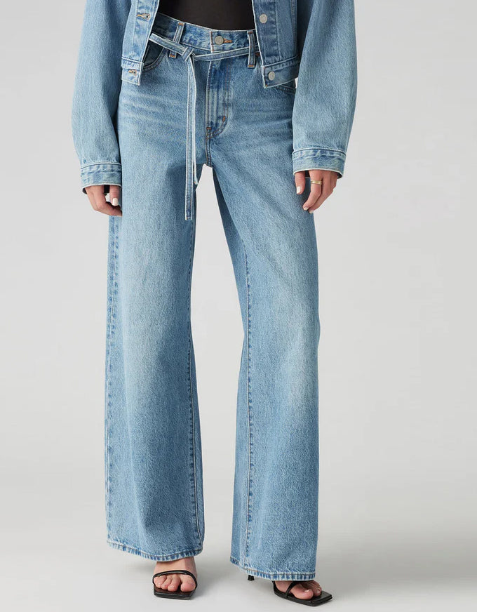 Person wearing light blue jeans and a denim jacket on a plain background. XL Straight Jeans - Thanks Friend